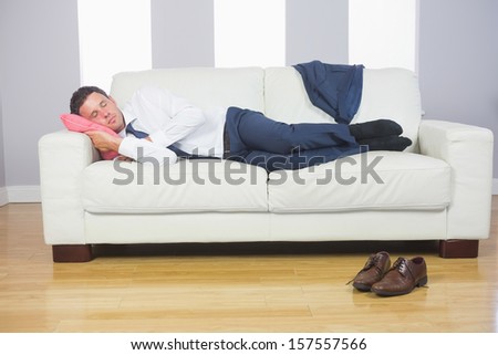 Calm attractive businessman lying on couch after work at home