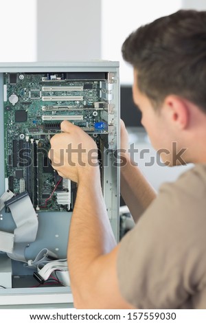 Computer engineer repairing computer in bright office