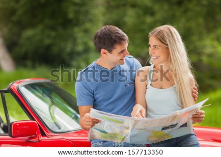 Happy young couple on a sunny day reading map