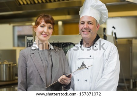 Mature Head Cook Posing With The Female Manager In A Professional Kitchen