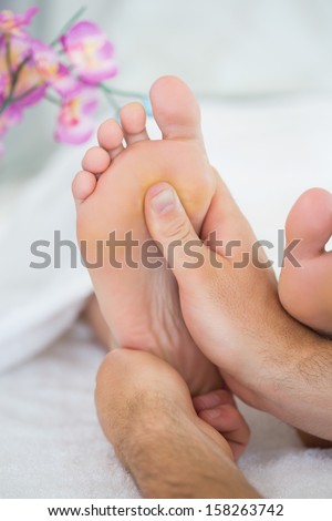 Close up of physiotherapist giving a patient a foot massage treatment in bright office