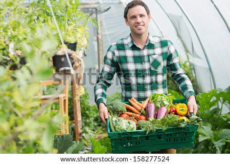 Proud Man Presenting Vegetables In A Basket Standing Greenhouse