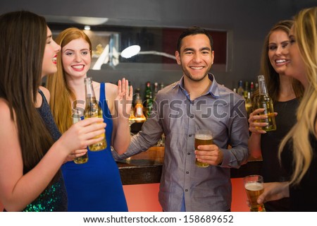 Happy friends holding beers and chatting in the nightclub