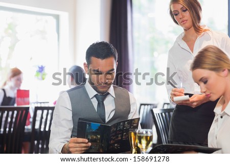 Handsome businessman reading the menu in a fancy restaurant