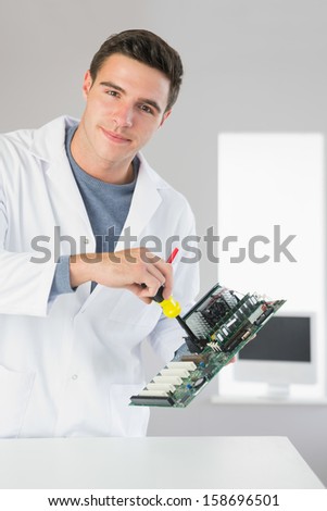 Attractive content computer engineer repairing hardware with screw driver in bright office