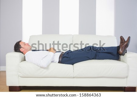 Calm Handsome Businessman Lying On Couch After Work At Home