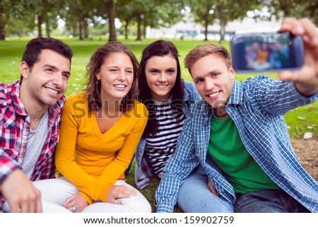 Happy male taking picture with his college friends in the park
