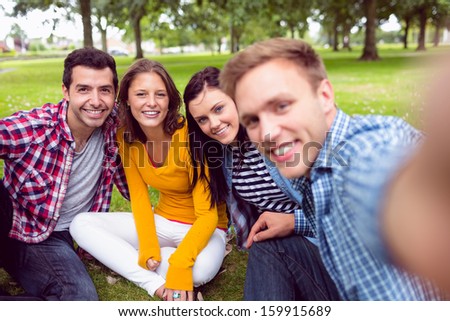 Group portrait of cheerful young college students in the park