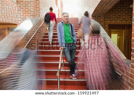 Casual handsome student standing on stairs in college