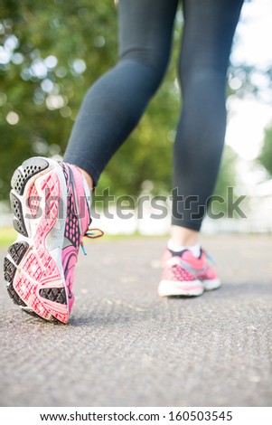 Close up picture of pink running shoes on a path in the park