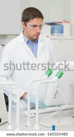 Serious male researcher using computer in the laboratory
