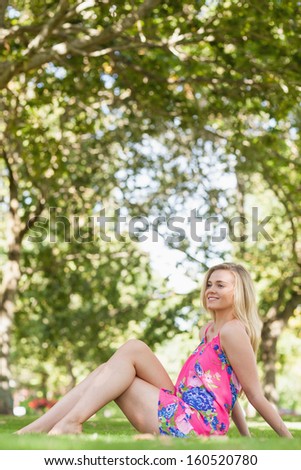 Cute casual woman relaxing on a lawn in a park