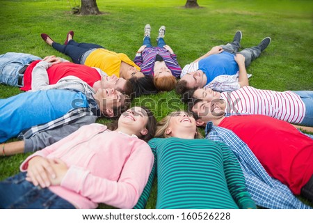 High angle view of a group of friends laying in a circle at park