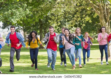 Full length of a group of college students running in the park