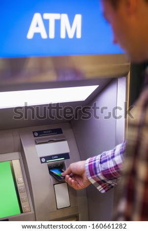 Casual student withdrawing cash at an ATM