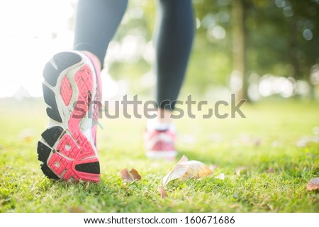 Close up picture of pink sole from running shoe in a park on a sunny day