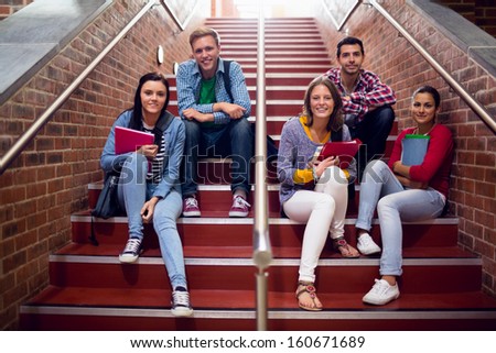 Group Portrait Of Young College Students Sitting On Stairs In The College
