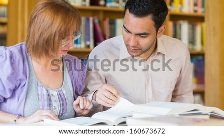 Two mature students studying together in the library