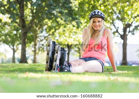Casual happy blonde wearing roller blades in a park