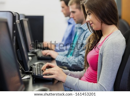 Side view of young students using computers in the computer room