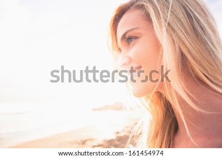Close Up Of A Smiling Relaxed Young Blond Looking Away At The Beach
