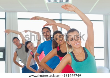 Portrait of sporty people doing power fitness exercise in row at yoga class