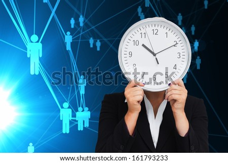 Composite image of businesswoman in suit holding a clock against white background