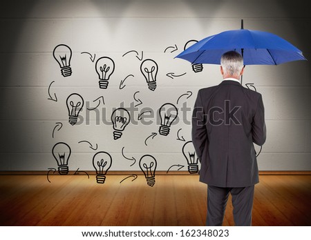 Composite image of mature businessman holding umbrella