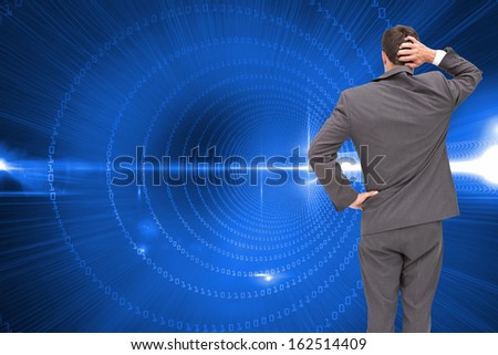 Composite image of young businessman standing back to camera scratching his head
