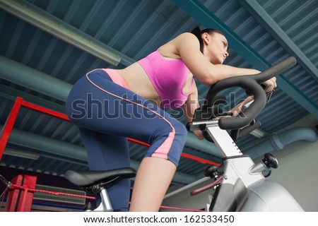 Low angle view of a determined young woman working out at class in gym