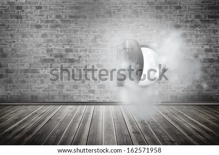 Open safe in dust cloud on brick lined wall