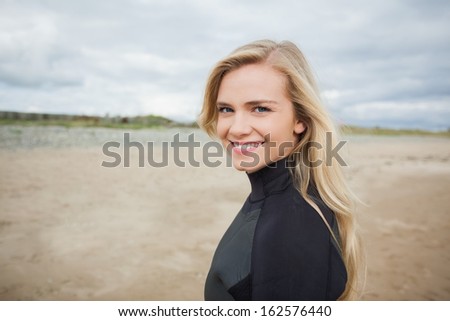Portrait of a beautiful young woman in wet suit at the beach