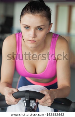 Determined young woman working out at class in gym