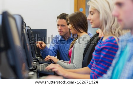 Side View Of Teacher Showing Something On Screen To Student In The Computer Room