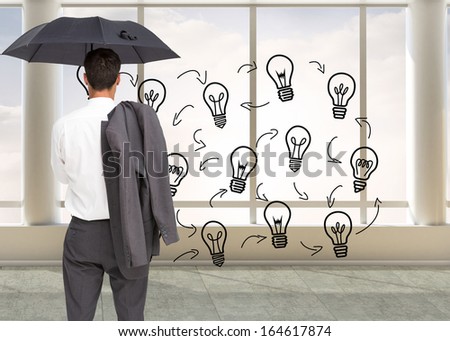 Composite image of businessman standing back to camera holding umbrella and jacket on shoulder