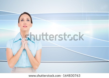 Composite image of troubled young businesswoman praying while posing