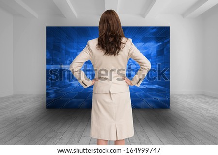 Composite image of businesswoman standing back to camera with hands on hips