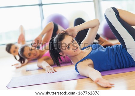 Class And Instructor Doing Stretching Pilate Exercises In Fitness Studio