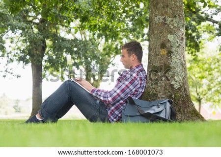 Young student using his laptop to study outside on college campus