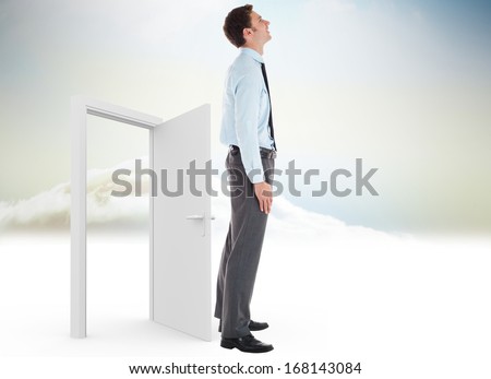 Smiling businessman standing with hand in pocket against open door in sky