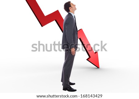 Happy businessman with hand in pocket against red arrow pointing down