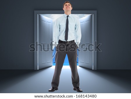 Smiling businessman standing with hands in pockets against server tower seen through window