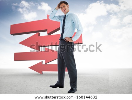 Thoughtful businessman with hand on head against red arrows in a desert landscape
