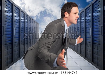 Businessman posing with hands out against server hallway in the sky