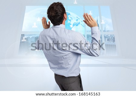 Businessman standing with arms pushing up against server tower seen through window