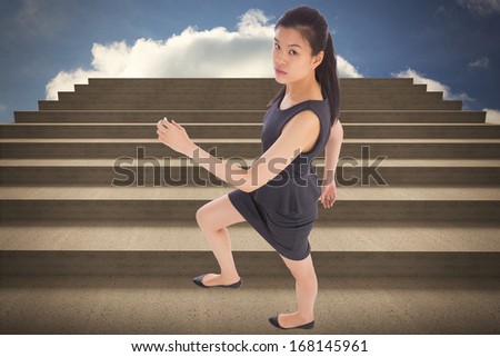 Businesswoman stepping up against steps against blue sky