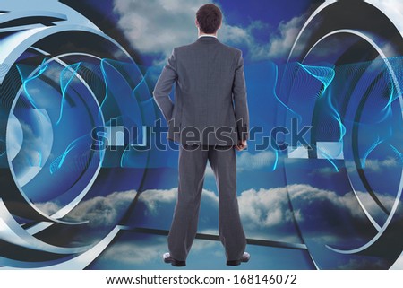 Businessman standing with hand on hip against abstract blue design in futuristic structure