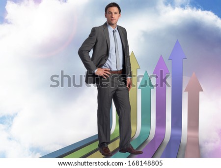 Serious businessman with hand on hip against unfinished bridge