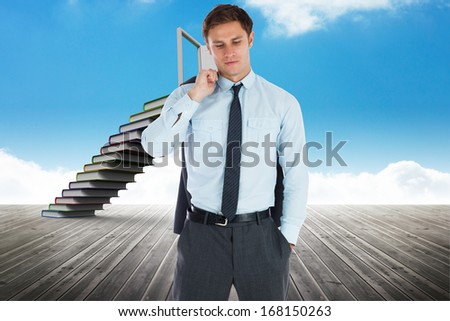 Serious businessman holding his jacket against book steps leading to door against sky