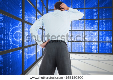 Thinking businessman with hand on head against glowing key seen through window